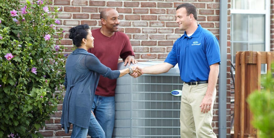 Ductworks HVAC worker shaking hands with a man and woman | Air Conditioning Authorized Carrier Dealer in Southington, CT